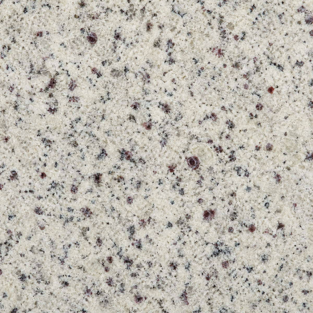 Close-up of a polished Colonial White granite countertop, pale cream scattered with grey and dark burgundy garnet crystals