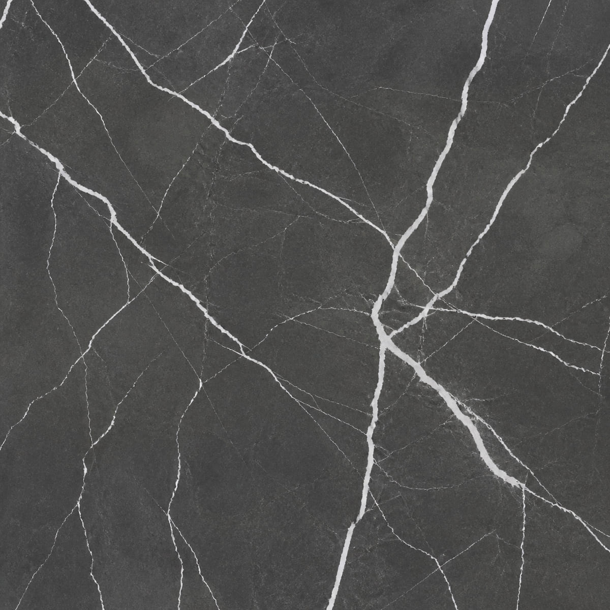 Close-up of a matte charcoal porcelain countertop with sharp white veins forking in angular branches