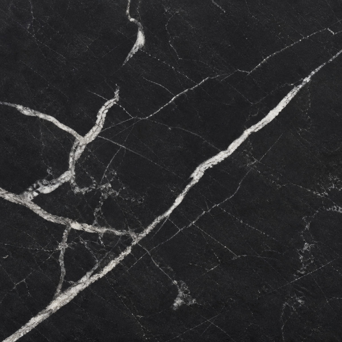 Close-up of a honed Black Venata soapstone countertop, near-black with bold bright white branching veins